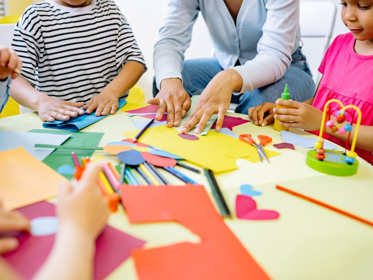 Kinder basteln gemeinsam mit Papier und Schere