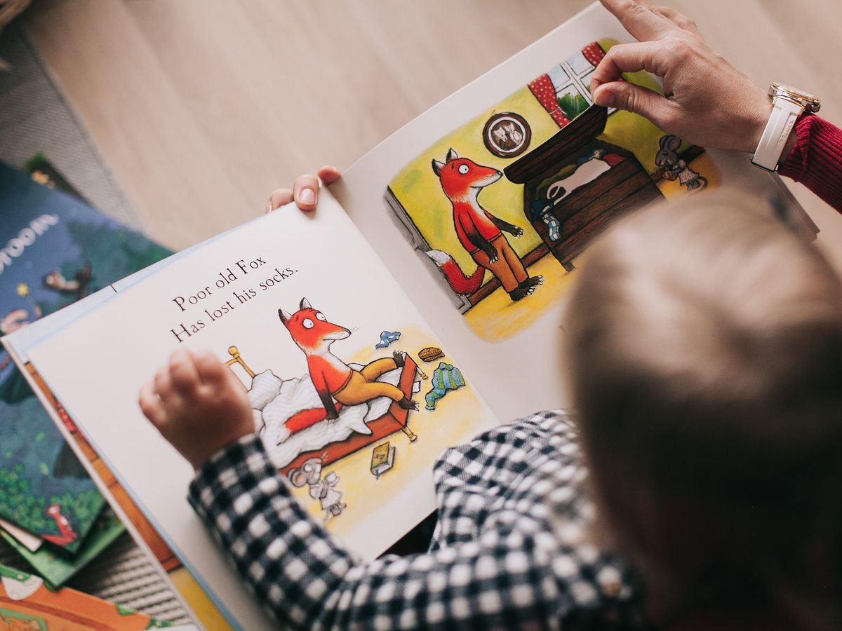 Ein Kind betrachtet ein aufgeschlagenes Bilderbuch